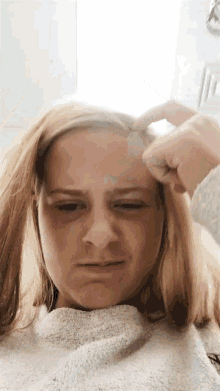 a young girl is making a funny face while holding her hair