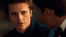 a man touches another man 's face while looking at him