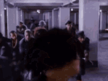 a blurry picture of a group of people walking in a room .
