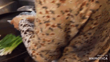 a woman is cooking vegetables in a frying pan in a restaurant kitchen .