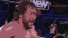 a man in a wrestling ring with a aew logo in the background