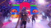 a man and a woman are walking through a colorful tunnel with a sign that says axxom on it .