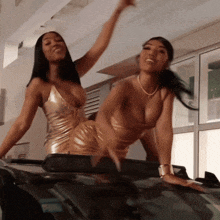 two women in gold dresses are posing for a picture