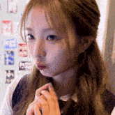a close up of a girl 's face with a sticker on the wall behind her that says ' a ' on it
