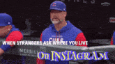 a man in a chicago cubs hat is standing in the dugout