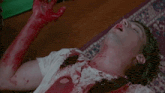 a man is laying on the floor with blood on his face and hands