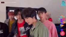 a group of young men are standing next to each other in a room with hearts flying around them .