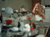 a woman is blow drying her hair in a room with stuffed animals and a candle that says ' a ' on it