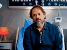 a man with a beard is in a hospital bed