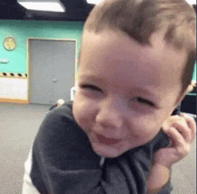 a little boy is smiling while being held in a room .