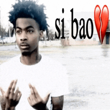 a man in a white shirt is giving the middle finger with the words si bao behind him