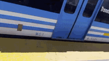 a blue and white train with the number mc1 on the side of it