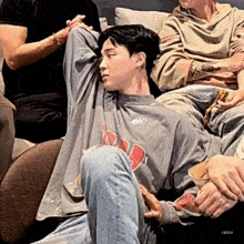 a group of people are sitting on a couch with their arms outstretched .