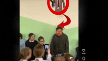 a group of children are taking a picture of a man