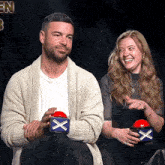 a man and a woman are sitting next to each other holding boxes with x 's on them