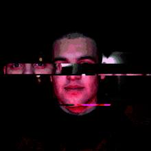 a close up of a man 's face with a pink and green glow