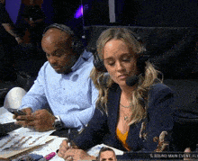a man and a woman wearing headphones are sitting at a table