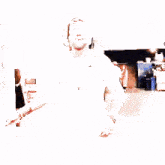 a man with a beard wearing a white shirt and a baseball cap is walking down a hallway .