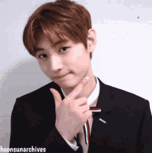 a young man in a suit and tie is making a funny face