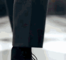 a person wearing a suit and black shoes is walking on a white floor .