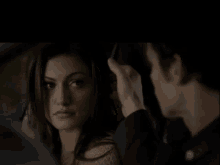 a man putting his hand on a woman 's head