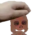 a hand is holding a cartoon character 's head with a sad face .