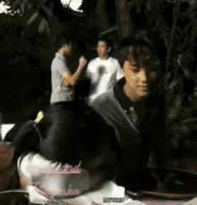 a group of people are gathered in a park and one of them is wearing a shirt that says ' girlfriend aka '