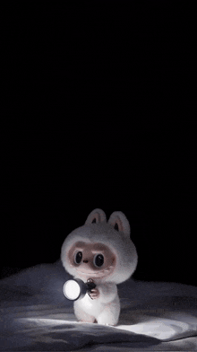 a stuffed animal is holding a flashlight in its mouth