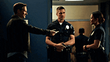 two police officers are talking to a man and a woman