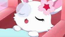 a white rabbit with a pink flower on its head is sleeping in a pink chair
