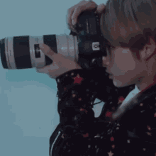 a person is holding a canon camera in their right hand