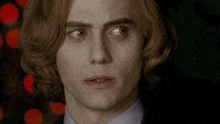 a close up of a man 's face with long red hair and brown eyes