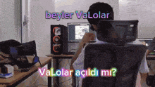 a man is sitting in a chair in front of a computer with the words beyler valolar valolar acildi mi