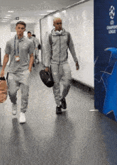 two men are walking in a hallway with a sign that says champions league