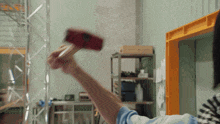 a person is holding a red hammer in their right hand
