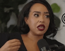 a woman is talking into a microphone and making a face .