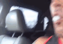 a man is sitting in the back seat of a car with a bandage on his face .