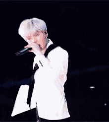 a man in a suit is singing into a microphone .