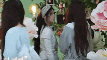 three women are standing in front of a wall with pictures on it and the words " i 'm all over " on the bottom