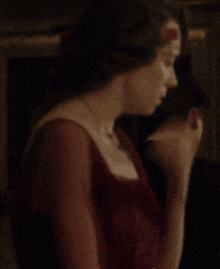 a woman in a red dress is covering her face