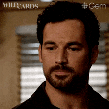 a close up of a man 's face with a wildcards logo in the background