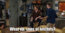two men are sitting on a couch with the words what up sons of bitches