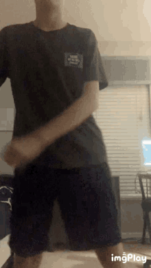 a man wearing a vans off the wall t-shirt is dancing