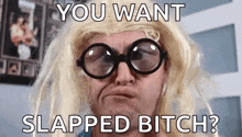 a man wearing glasses and a blonde wig is making a funny face with the words `` you want slapped bitch ''