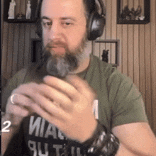 a man with a beard is wearing headphones and a shirt that says miami