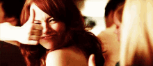 a woman with red hair is making a funny face with her hand .