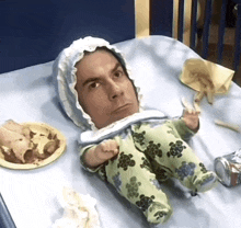 a baby with a man 's face on it is laying on a bed