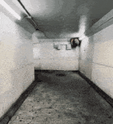a very long narrow hallway with a ceiling fan