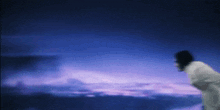 a person is standing in front of a purple sky