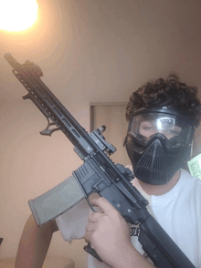 a man wearing a paintball mask holds a rifle